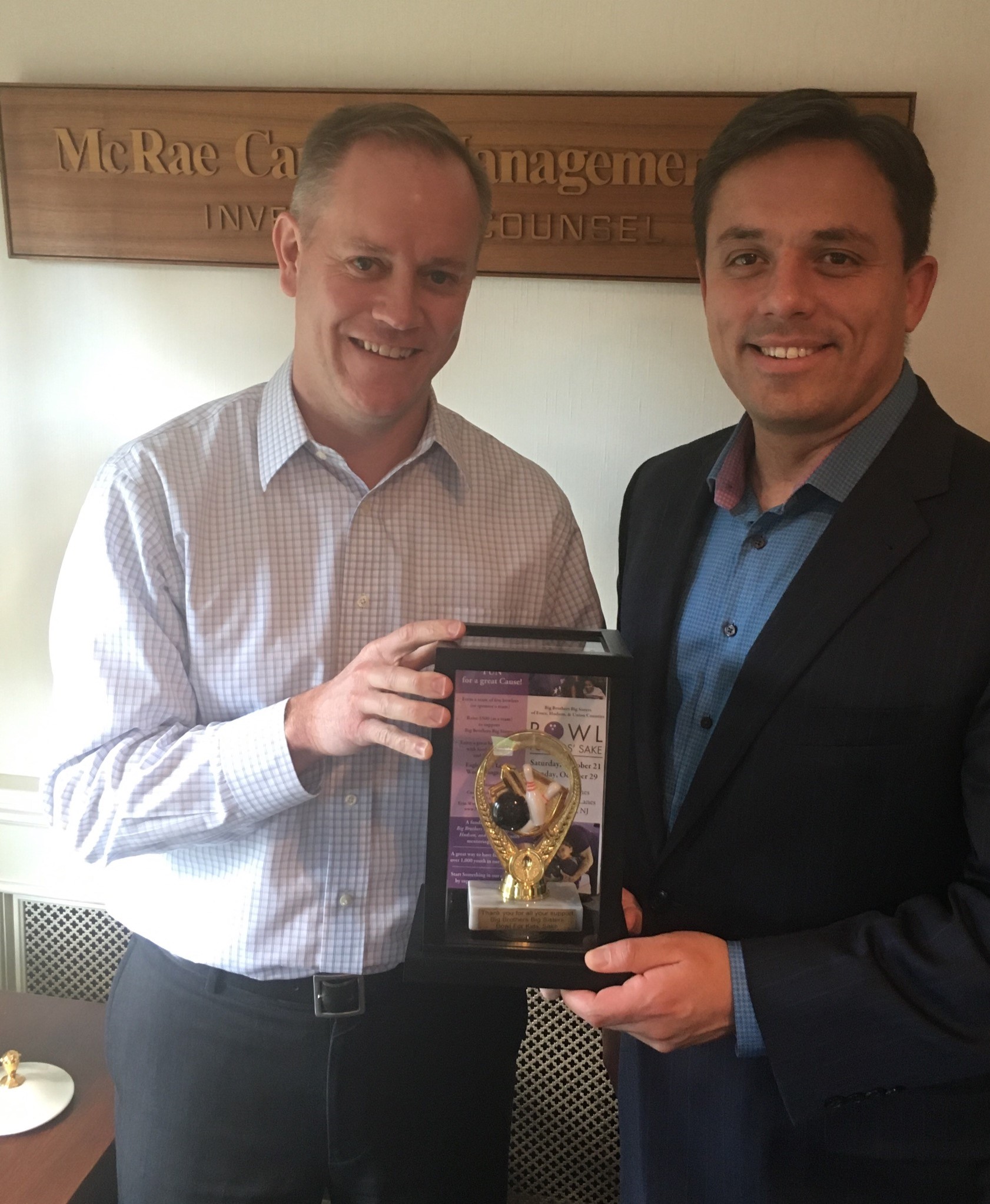 Peter McRae of McRae Capital Management is given a bowling trophy by BBBS regional CEO Carlos Lejnieks to recognize McRae's longtime support of Big Brothers Big Sisters of New Jersey (BBBS) at the Bowl For Kids Sake (BFKS) event in 2017.