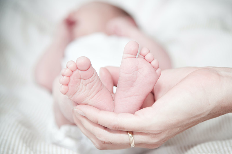 mom holding baby feet