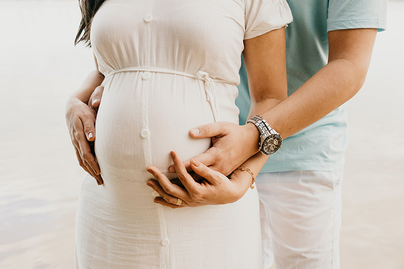 husband holding wife's pregant belly